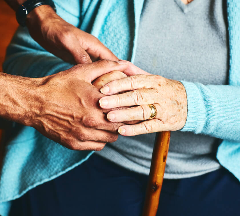Elder woman holding hands with someone else